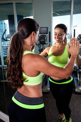 Fototapeta premium young brunette woman exercising and stretching in a gym