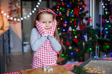 Adorable little girl in wore mittens baking Christmas