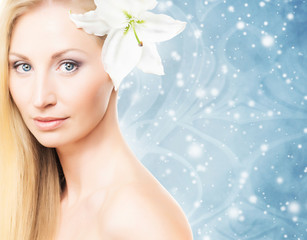 Fototapeta premium A woman with a fresh lily flower on an abstract background