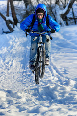Cyclist riding on a mountain bike in the snow winter forest