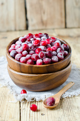 Cranberries in a wooden bowl on a wooden table