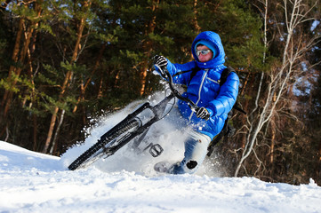 Cyclist riding on a mountain bike in the snow winter forest