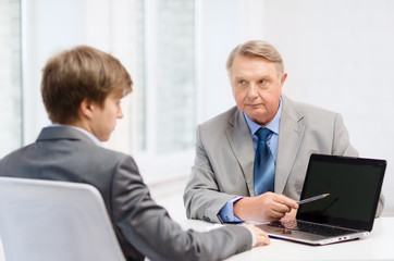 Fototapeta premium older man and young man with laptop computer