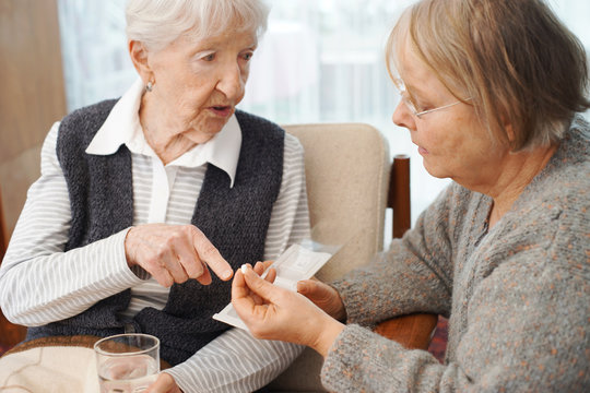 Elderly lady with family or caretaker discussing her medications