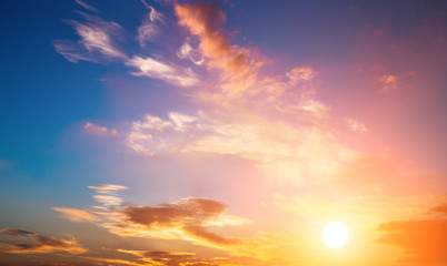 Dramatic sunset sky with orange colored clouds and sun.