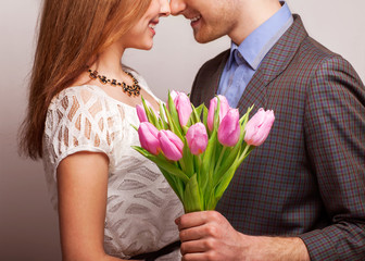 couple in love with a bouquet of tulips are close to each other