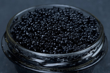 glass jar of black caviar, selective focus, close-up