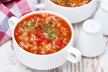 tomato soup with rice and vegetables in a bowl, top view