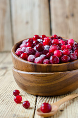 Cranberries in a wooden bowl on a wooden table