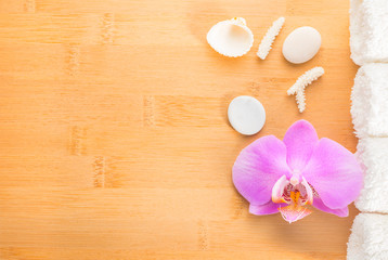 branch lilac orchid, shells  and white towels on bamboo wooden