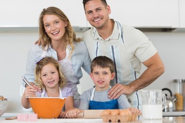 Happy family baking cookies at kitchen counter
