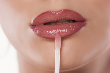 Woman applying lip gloss