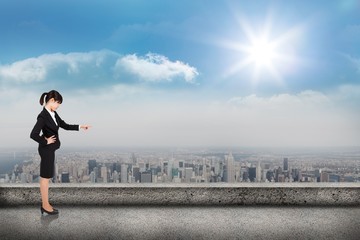 Composite image of focused businesswoman pointing