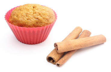 Fresh baked carrot muffin and cinnamon stick. White background