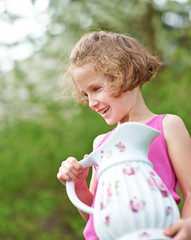 Mädchen trägt Wasser im Krug aus Porzellan