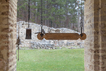 Monastry hammer lying on a wooden plank with monastery bells