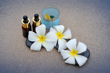 white  frangipani flower with  essential oil and zen stone
