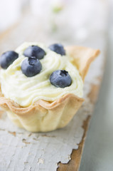 Tart with blueberries and cheese cream on old wood