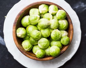 Brussels sprouts in a wooden bowl on the table, tasty, healthy