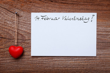 red heart hanging before wooden board