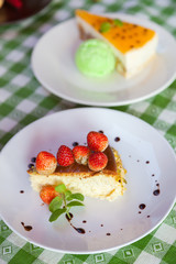 Cheese cake and ice-cream on plate with fruit topping.