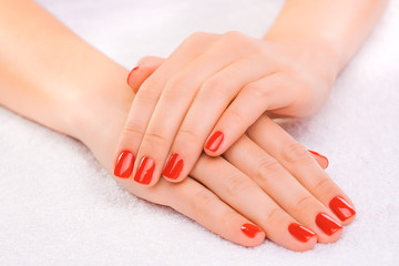 red manicure on the white towel