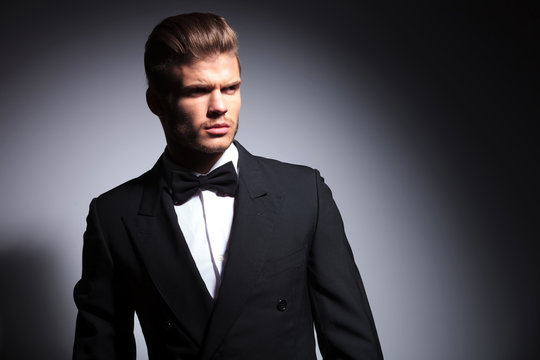 attractive young man wearing elegant black suit and bow tie