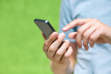 boy holding a phone and a touch screen for finger against a gree