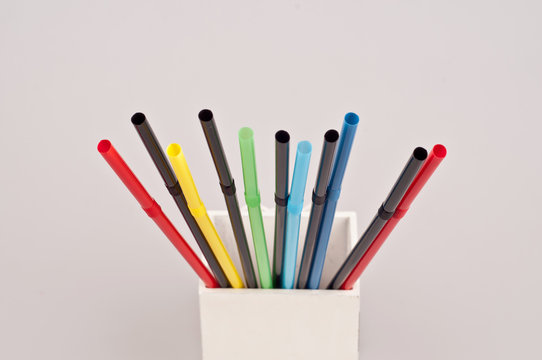 Many colorful straws in wooden white stand