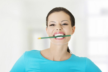 Thoughtful woman biting pencil