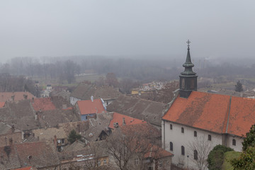 Fototapeta premium Novi Sad city roofs and church in fog