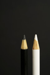 black and white coloured pencil crayons on a black background