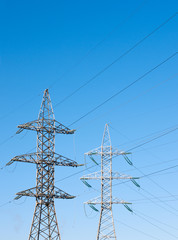 High voltage power lines against the blue sky