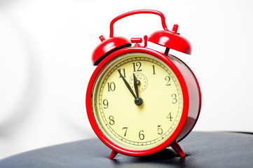 red alarm clock in a retro style shot in a studio