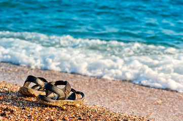 a pair of flip-flops left on the shore