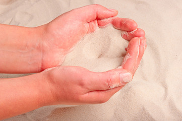 fine sand flowing out of women's hands