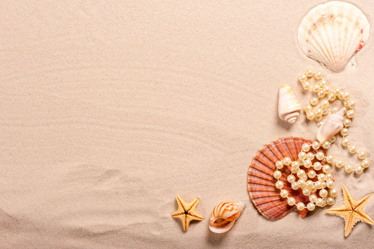 pearl beads and seashells in the sand