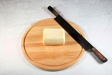 block of cheese on a wooden plate with decoration