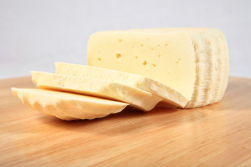 block of cheese on a wooden plate with decoration
