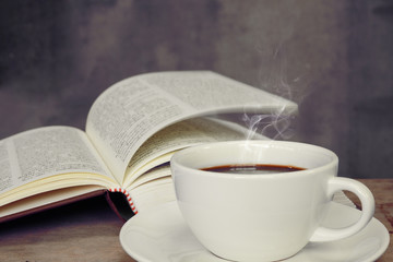 Still life with cup of coffee and book on grunge wood table in v