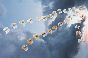 flock of flying books in storm clouds