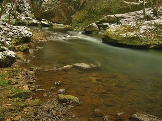 Dark cold water of mountain stream in winter time