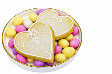 Two heart shaped cookies on a late with sugared almonds.