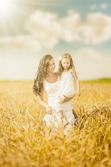 Mother and daughter among wheat ears