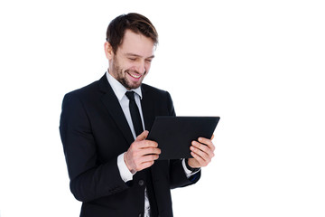 Businessman smiling as he reads a tablet-pc