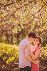 Fototapeta premium Portrait of young couple in flowering park