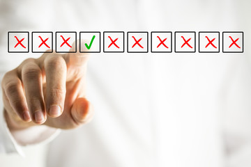 Man selecting a ticked box from amongst crosses