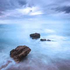 Foto auf gebürstetem Alu-Dibond Meer / Ozean Rocks in a ocean waves under cloudy sky. Bad weather.