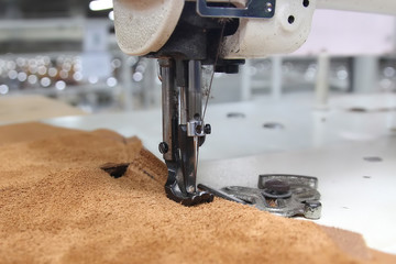 Closeup of sewing machine working part with leather