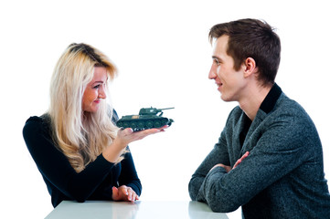 young beautiful woman gives a man a toy tank